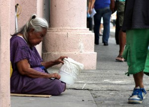 ON THE SIDELINES. An old beggar asks for alms while others were busy catching a view of the parade during the 75th Araw ng Dabaw celebration. (davaotoday.com photo by Ace R. Morandante)