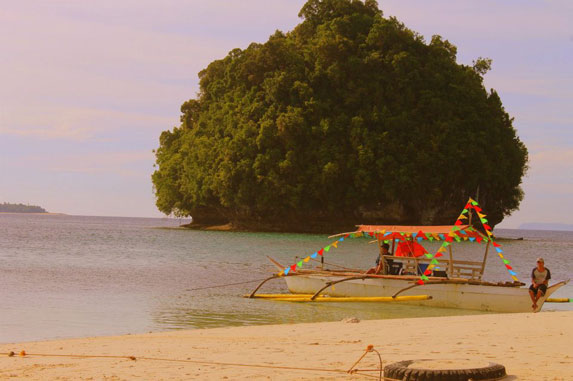 Boatmen taking a rest while waiting for their passengers. The island in the background is the Panlangagan Cave.