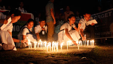 REMEMBERING THE VICTIMS. Students of the Assumption College of Davao light candles on Thursday outside the Redemptorist Church in Davao City. They remember the 58 individuals who were brutally killed in Ampatuan, Maguindanao Province three years ago. (davaotoday.com photo by Medel V. Hernani)