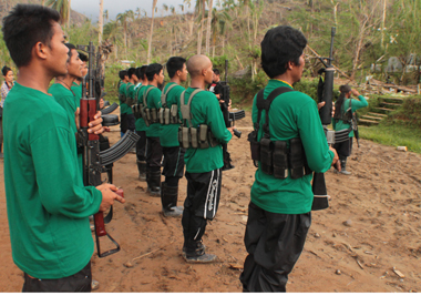 GUN SALUTE. Members of the New People’s Army offer a gun salute while singing the Internationale Wednesday during the closing of the 44th founding anniversary celebration of the Communist Party of the Philippines somewhere in Compostela Valley province. (davaotoday.com photo by Ace R. Morandante)