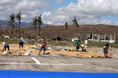 DRYING. Workers of the Cateel rice mill in Davao Oriental try to dry rice under the heat of the sun Friday, days after typhoon Pablo destroyed 2,860 hectares of rice fields in the town. (davaotoday.com photo by John Rizle L. Saligumba)