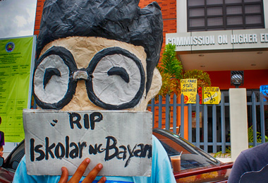 ISKO STAYING ALIVE. The student mascot Isko (colloquial for Iskolar ng Bayan (Scholars of the Nation) shows a placard lamenting the death of youth scholars in state universities with the suicide of UP student Kristel Tejada due to "commercialization of education." Students staged a picket in front of the CHED regional office, Monday. (davaotoday.com photo by Medel V. Hernani)