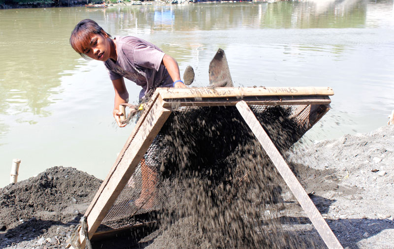 ODD JOB.  Ryan Lupas, 18 of New Matina Gravahan in Davao City earns PHP 150 a day from sifting sand for making hollow blocks.  He said unemployed residents like him look out for opportunities such as this to sustain their family’s needs.  (davaotoday.com photo by Medel V. Hernani)
