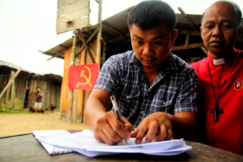 RELEASED.  SPO2 Allan Mariquit Pansoy signs his release order from the New People’s Army Saturday in a village in Maco town, Compostela Valley.  He was turned over to peace advocacy group Sowing the Seeds of Peace in Mindanao and local government officials.  (davaotoday.com photo by Ace R. Morandante)