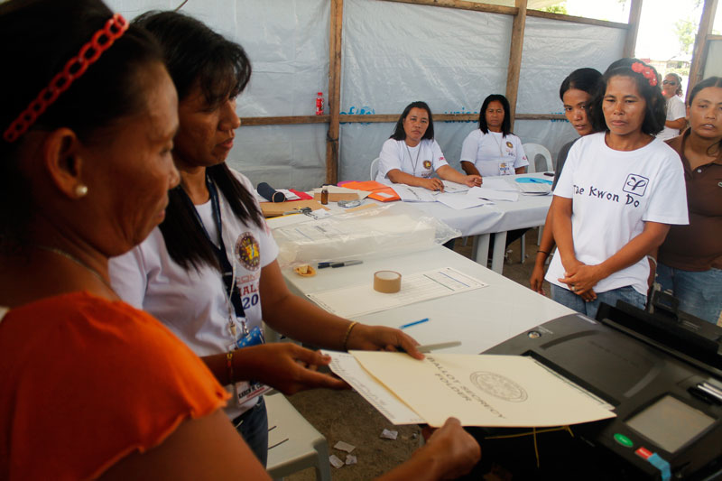 TENT CENTER.  In San Rafael Elementary School, Cateel town, Davao Oriental, voters cast their vote inside the Pablo-damaged classrooms covered only with tarpaulins.  (davaotoday.com photo by John Rizle L. Saligumba)