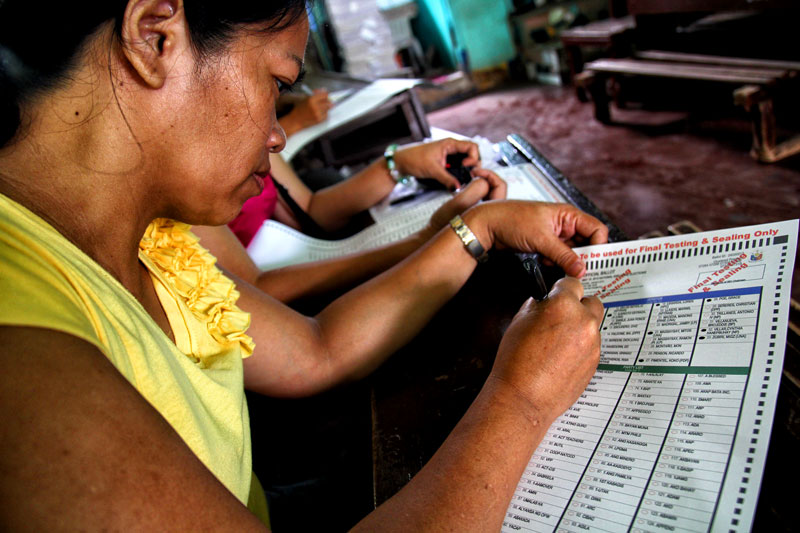 TEST.  A poll watcher casts her vote during the final testing and sealing of PCOS (precinct count optical scanner) machines Monday in Davao City’s Cesario Villa Abrille Elementary School (formerly Bucana Elementary School).  (davaotoday.com photo by Ace R. Morandante)