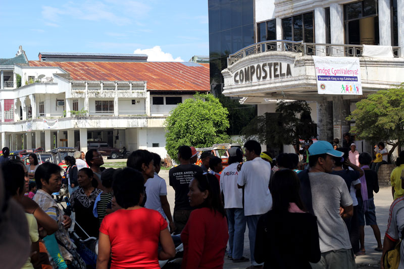 VIGILANCE.  Supporters of two opposing candidates for mayor in Compostela town troop outside the municipal hall Wednesday morning to watch over the PCOS machine assigned in Purok 2, Poblacion village.  According to the BEI of precinct 8, the machine’s memory card was defective and has to be brought to the capitol in Nabunturan town for manual counting.  But the camp of Adolfo Ang opposed the plan, worrying for “anomalies.”  (davaotoday.com photo by Ace R. Morandante)