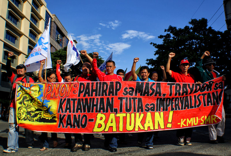 WITH CLENCHED FISTS. Leaders of progressive organizations in Davao City lead the march of more than a thousand participants for the International Labor Day celebration Wednesday. Labor center Kilusang Mayo Uno said if the Aquino government continues to ignore the demands of the working class and the people, currents of resistance are inevitable. (davaotoday.com photo by Ace R. Morandante)