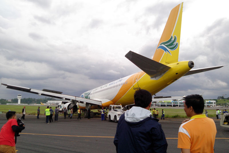 HALFWAY. At 4:30 PM Tuesday, about half of the Cebu Pacific aircraft is extricated from the grassy part of the Francisco Bangoy International Airport runway. The Civil Aviation Authority of the Philippines has given Cebu Pacific only until Tuesday morning to remove the plane which paralyzed the international gateway, caused thousands of passengers to be stranded and an estimated loss of PHP 250 Million to the local economy. (davaotoday.com photo by John Rizle L. Saligumba)