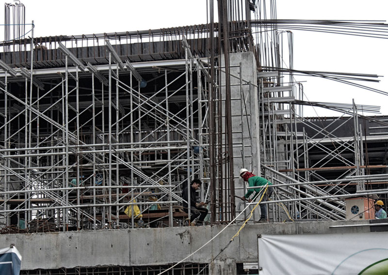 IN FULL SWING.   Workers are busy constructing this real estate building located within a two-hectare land along Davao City’s Quimpo Boulevard.  (davaotoday.com photo by Medel V. Hernani)