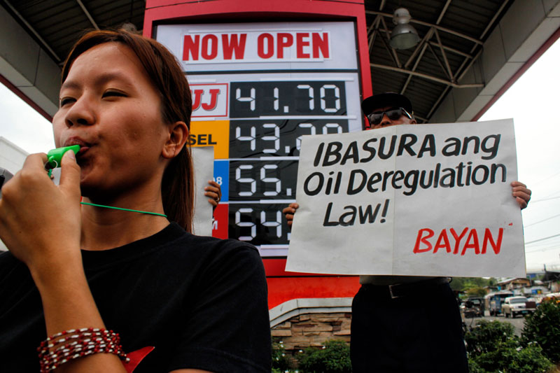 JUNK THIS LAW!  Umbrella organization Bagong Alyansang Makabayan holds a ‘noise barrage’ Tuesday at a gas station along Acacia Street, Davao City.  This after the prices of oil products increased six times since May or during the elections.  Sheena Duazo (left), spokesperson for Bayan in Southern Mindanao, said they want the Oil Deregulation Law repealed as this hasn’t served its purposed of lowering the costs but only caused so much price increases.  (davaotoday.com photo by Medel V. Hernani)