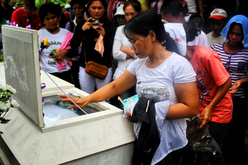 LAST GOODBYE.  As Eddie Cañon is laid to rest on Monday in Mawab town, Compostela Valley, her wife bids the last farewell.  Cañon, a coordinator for Anakpawis party-list, was allegedly killed by state agents last May 25 in Nuevo Iloco village.  (davaotoday.com photo by Ace R. Morandante)