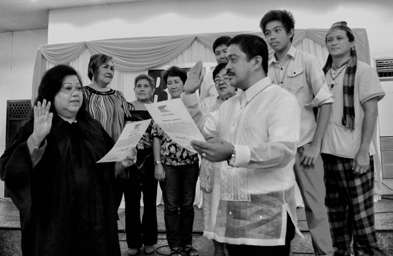 OATH-TAKING.  Bayan Muna Party’s Representative-elect Carlos Isagani Zarate takes oath before Judge Virginia Europa Friday in Garden Oases, Davao City.  Behind him are his family and representatives from the groups of lawyers and Lumads in Mindanao.  Zarate said he will continue to fight for the people’s welfare and interests, this time in the halls of Congress.  (davaotoday.com photo by Medel V. Hernani)