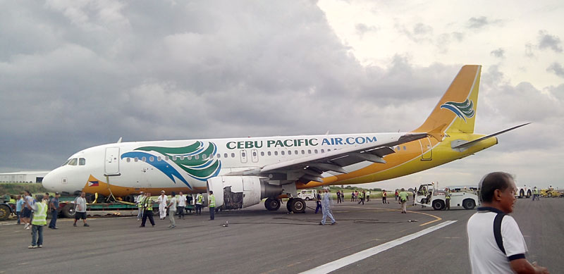 REMOVED.  At 5:10 PM Tuesday, the Cebu Pacific aircraft is extricated from the grassy part of the Francisco Bangoy International Airport runway.  The Davao City Tourism, Investment and Promotion Office said the local economy lost about PHP 25o Million after the international gateway was paralyzed due to the runway mishap.  (davaotoday.com photo by John Rizle L. Saligumba)