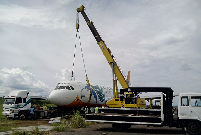 THE LIFT.  A crane tries to lift Cebu Pacific’s aircraft Tuesday afternoon at the Francisco Bangoy International Airport in Davao City.  The plane veered off the runway last Sunday evening blocking all flights until it’s extricated.  (davaotoday.com photo by John Rizle L. Saligumba)  
