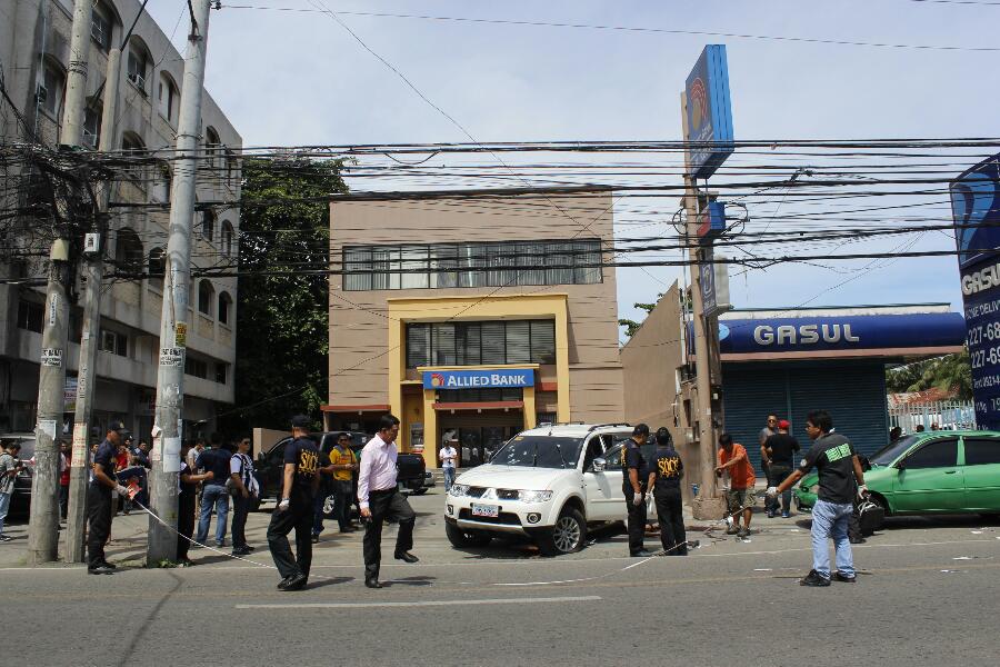 Members of Davao City Police cordon off a portion of downtown Claveria Street where two suspected members of a kidnap-for-ransom group inside this parked white Mitsubishi Montero vehicle were killed by authorities at around 12 noon Thursday. (www.davaotoday.com photo by Medel V. Hernani)
