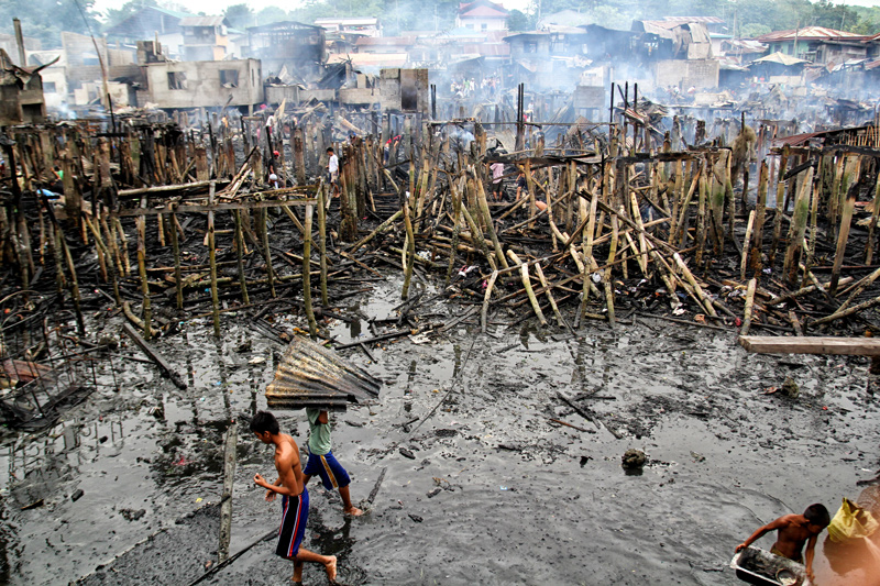 SALVAGING THE RUINS Only the stilts and burned roofs remained in this scene in Fatima Village, Km 11 in Sasa last Thursday when a fire gutted 200 houses and destroyed properties worth P 1.5 million.  (davaotoday.com photo by Ace R. Morandante)