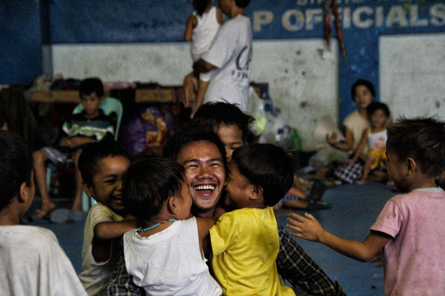 A youth volunteer enjoy warm hugs and smiles from Manobo children who left Saturday morning  to return to Loreto, Agusan del Sur after negotiations with their mayor assured them that soldiers are pulled out from their villages.  The Manobos stayed in Bankerohan Gym for 18 days with support from church and other groups. (davaotoday.com photo by Medel V. Hernani)