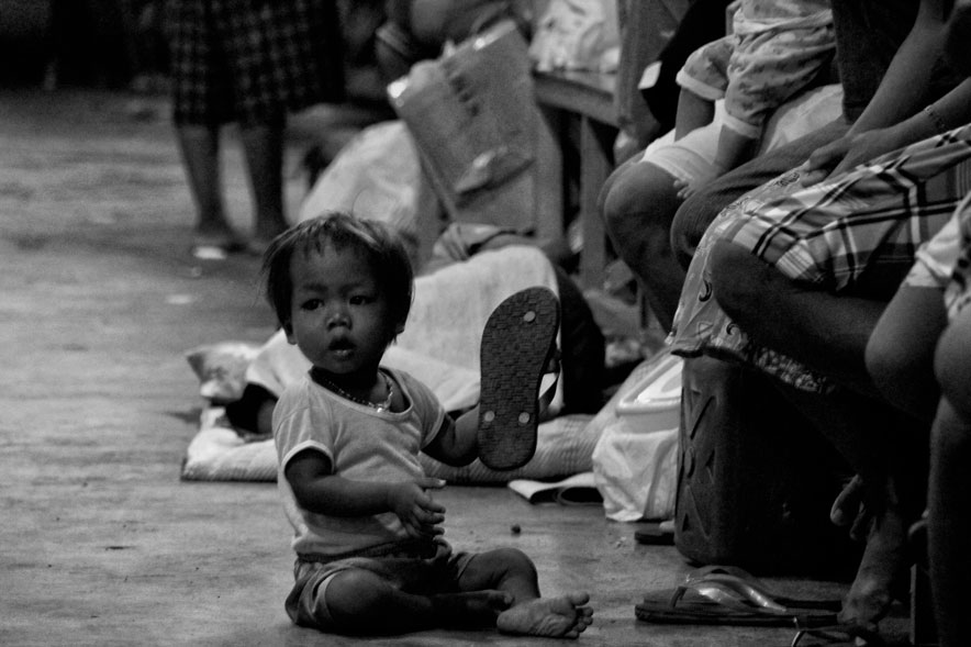 A Manobo toddler plays with a new pair of slippers given by support groups and the City Government as ‘parting gifts’ to the 500 Manobos who finally returned home to Loreto, Agusan del Sur after an agreement with their mayor that troops will be pulled out from their villages.  The support groups provided food, health and other needs for the Manobos in Davao for the past 18 days. (davaotoday.com photo by Medel V. Hernani)