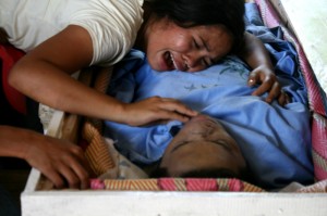 Sister of Benjie Planos, slain leader of the Agusan Manobo group, wails and clings to his body during his burial on Tuesday. Planos’ murder comes weeks after the Manobos returned to their community after an agreement to stop militarization in their community in Loreto, Agusan del Sur. The Manobos pin his murder on paramilitary and soldiers. (davaotoday.com photo by Earl O. Condeza)