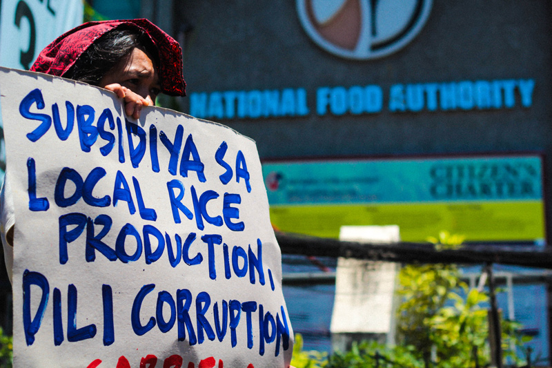 An urban poor activist from Samahan ng Maralitang Kababaihan (SAMAKANA) endures the heat as she joined other members in a picket at the gates of National Food Autority (NFA) protesting the skyrocketing price of rice which now ranged from 40 to 49 pesos a kilo. (davaotoday.com photo by Ace R. Morandante)