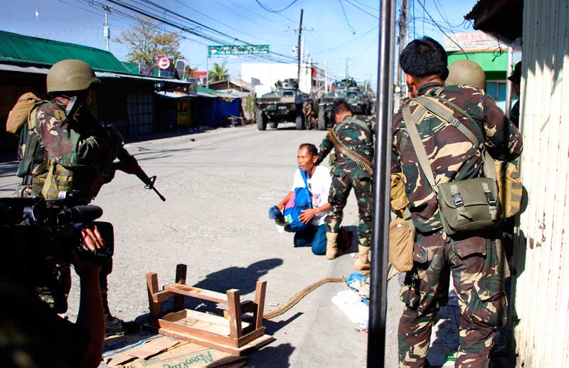 A government soldier takes ready aim at a Zamboanga civilian while his comrade holds the latter down. The person came out of Lustre Street where government troops were pursuing off MNLF rebels.  (davaotoday.com photo by John Rizle L. Saligumba)