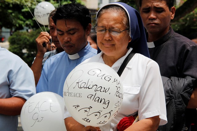 PRAYER FOR SYRIA A nun and priest holds balloons during a prayer for peace and justice in Syria, where conflict has prodded the United States to plan military air strikes in the area.  The activity held Saturday at Redemptorist Church echoed Pope Francis’ call for fasting and prayer against US military intervention. (davaotoday.com photo by Medel V. Hernani)