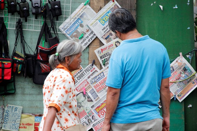 TODAY'S HEADLINES Passersby along corner San Pedro Cathedral and CM Recto read the latest headlines about Pope Francis’ call for prayer against the US military strike against Syria and the updates on the pork barrel probe (davaotoday.com photo by Medel V. Hernani)