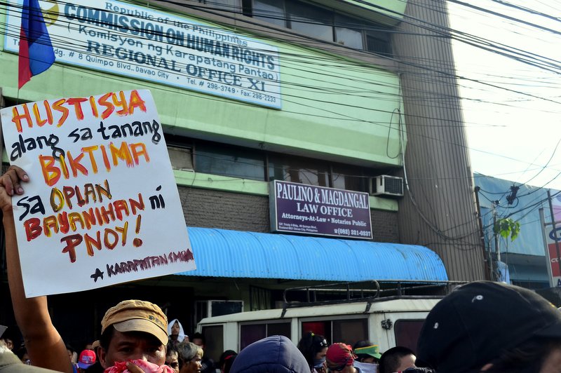 MESSAGE FOR CHR One of the protesters raises his placard during a picket on Tuesday at the office of the Commission on Human Rights, demanding for investigation of victims of extrajudicial killings. (davaotoday.com photo by Earl O. Condeza)