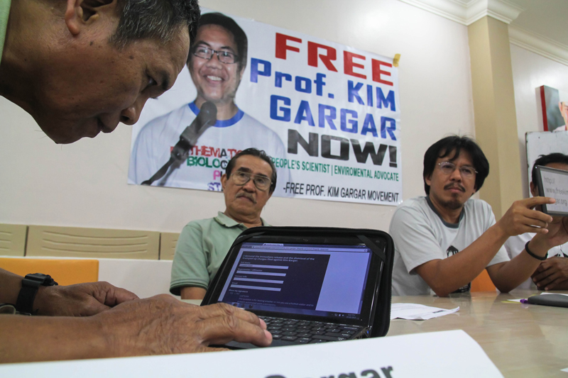 FATHER’S SUPPORT Emmanuel Gargar (left), father of detained scientist Professor Kim Gargar, types his name on a website created by Kim’s colleagues and rights advocates calling for his release.  Kim Gargar was conducting post-Typhoon Pablo studies in Cateel, Davao Oriental when he was detained and charged by the military that he is a New People’s Army member.  (davaotoday.com photo by Ace R. Morandate) 