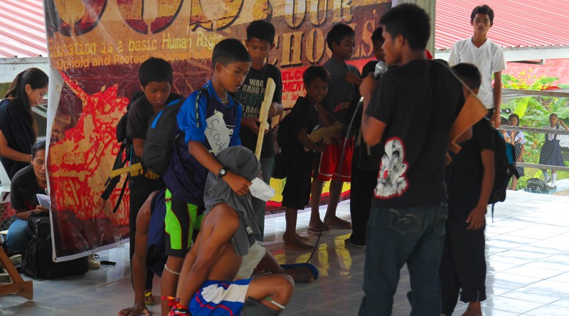 REENACTING THE HORROR Children of Barangay Mangayon, town of Compostela, Compostela Valley dramatize how they were harassed and forced by government soldiers to act as guides in their counter-insurgency operations . This was part of the Save Our Schools: Children's Camp launched by child advocates in Panansalan, Compostela last October 29 to call for the protection of children's rights in the observance of Children's Month. (davaotoday.com photo by Ace R. Morandante)