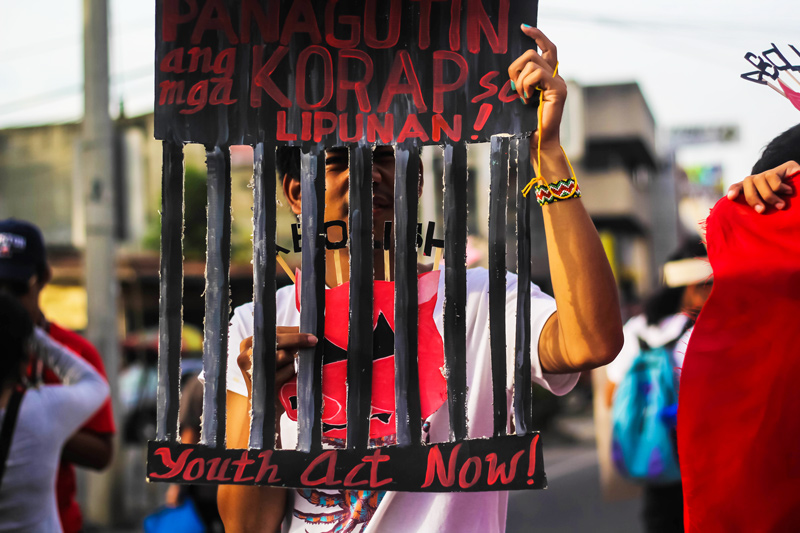 JAIL PORK USERS An activist from Youth Act Now calls for the prosecution of officials involved in corruption and misuse of pork during a picket Wednesday along Jones Circle in Acacia & CM Recto junction.  Anti-pork rallyists slam the Aquino's Presidential Social Fund and the Disbursement Acceleration Program (DAP) which they say promote patronage politics. (davaotoday.com photo by Ace R. Morandante)