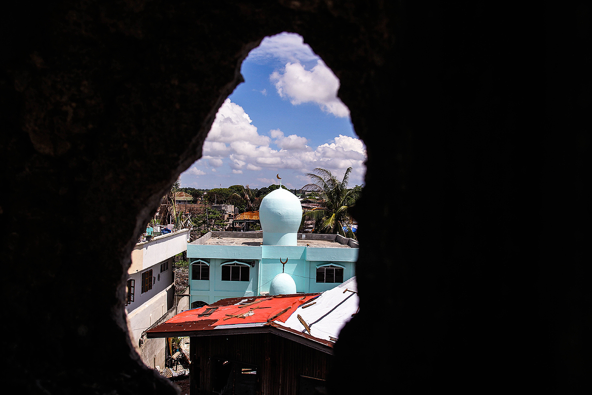 A hole in a building in Lustre Street peers through a mosque.  Many of these buildings were left in tatters during the Zamboanga standoff last September. (davaotoday.com photo by Ace R. Morandante)