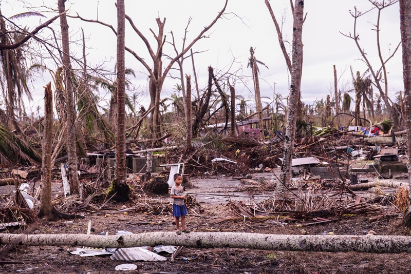 A kid stands amidst fallen trees in Palo, Leyte. (contributed photo by Ken Bandayanon)