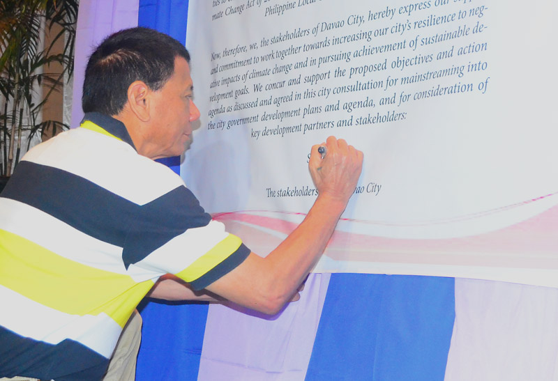 MAYOR'S SIGNATURE Davao City Mayor Rodrigo Duterte signs the city's commitment to climate change action in Tuesday's consultation with the United Nation's Habitat for Climate Change Adaptation at the Pinnacle Hotel. The consultation was attended by government and business sectors to discuss on the city's action on climate change. (davaotoday.com photo by Earl O. Condeza)