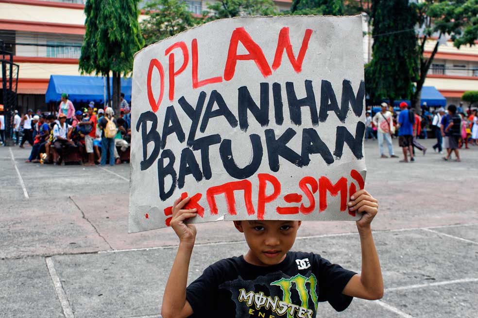 RAISE THE SIGN A child of a protester holds up a placard during a rally at Davao City’s Rizal Park commemorating the 65th International Human Rights Day.  (davaotoday.com photo by Medel V. Hernani)