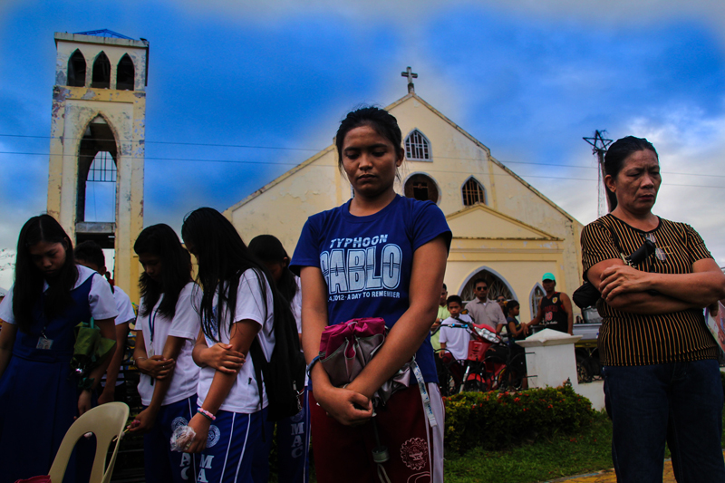 PRAYER  Students and other residents of Cateel, Davao Oriental prayed for the memory of victims of Typhoon Pablo during the first year commemoration of the storm that left around 1,000 dead or missing. (davaotoday.com photo by Ace R. Morandante) 