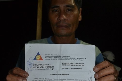 Namasufa union president Vicente Barrios shows the memorandum of agreement between Sumifru management, contract growers and union officials granting the return to work with back wages of 141 workers. (contributed photo)