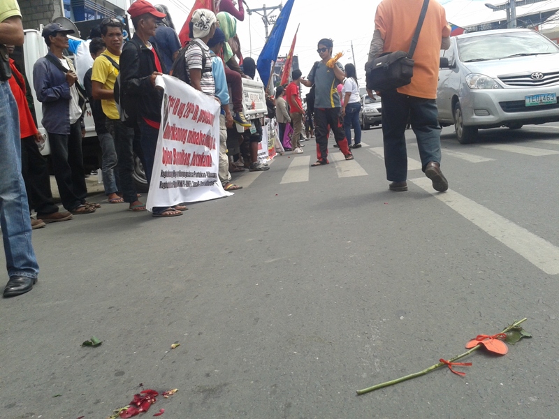 REJECTED. A rose given to rallyists from policemen who violently dispersed them earlier gets rejected as rallyists demand for justice for human rights violations reportedly committed by soldiers and now by the police. (Tyrone Velez/ davaotoday.com)