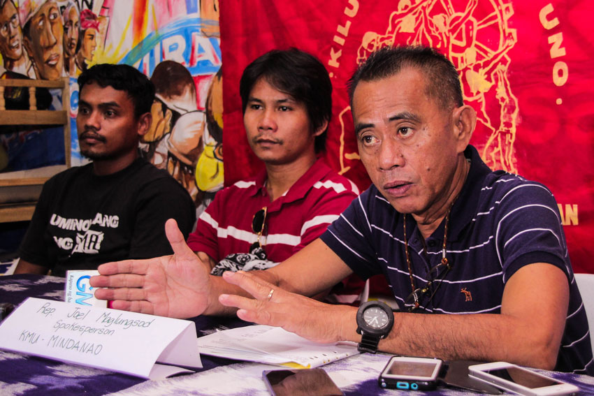 Joel Maglunsod (right) of the labor group Kilusang Mayo Uno joins workers of Superstar Coconut Products in demanding the Department of Labor to enforce occupational safety standards following the factory accident that killed one worker.