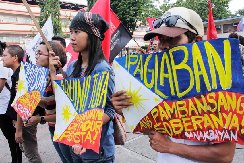 Youth activists flash the Philippine Flag with slogans during an Independence Day rally at Rizal Park depicting current public clamor for nationalist politics against government corruption. (contributed photo by Jaja Necosia) 