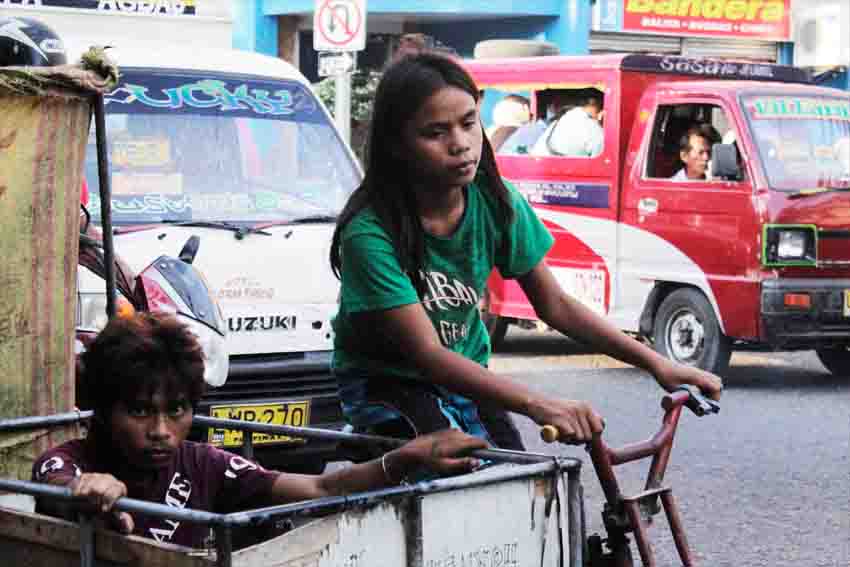  It's an exhausting day for this young girl who bikes off with her brother looking for useful trash as they navigate the tight road along C. Bangoy corner Palmagil, Davao City.