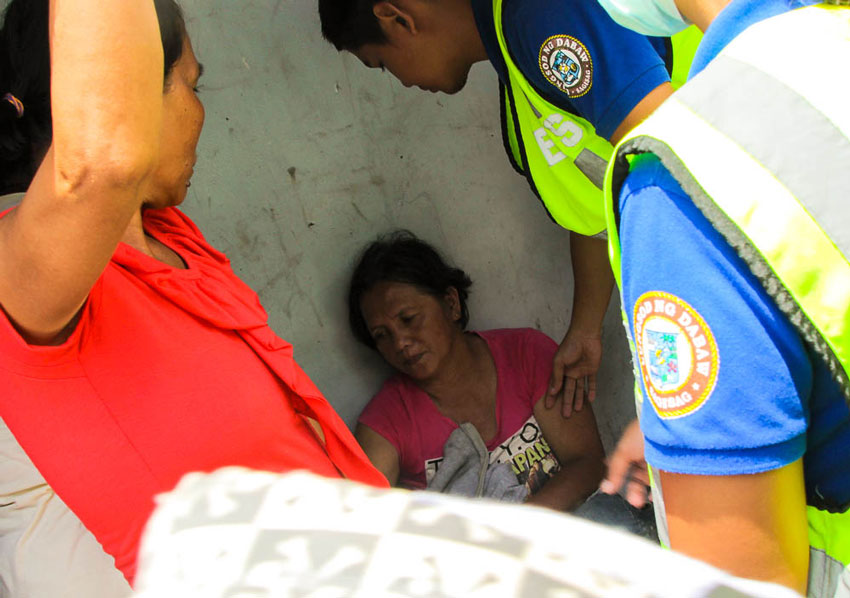  Leticia Lumakan, 51, of Magpet, North Cotabato faints under the heat of the sun while lining up with other victims of Martial Law, to file her compensation claim. This happened outside the Bankerohan gymnasium at 11:30 in the morning, but she refuses to get treatment from 911 medical team, so she will not miss her turn in the claims board.