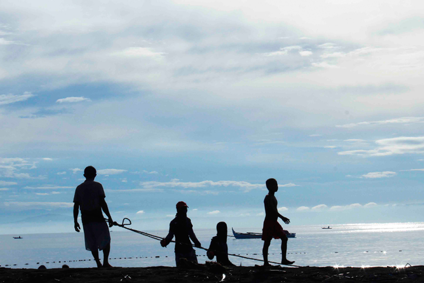 Fisherfolks at Inawayan, Tori pull back their nets as the morning sun comes up. At times fisherfolks will catch a sack full of krill or shrimps.