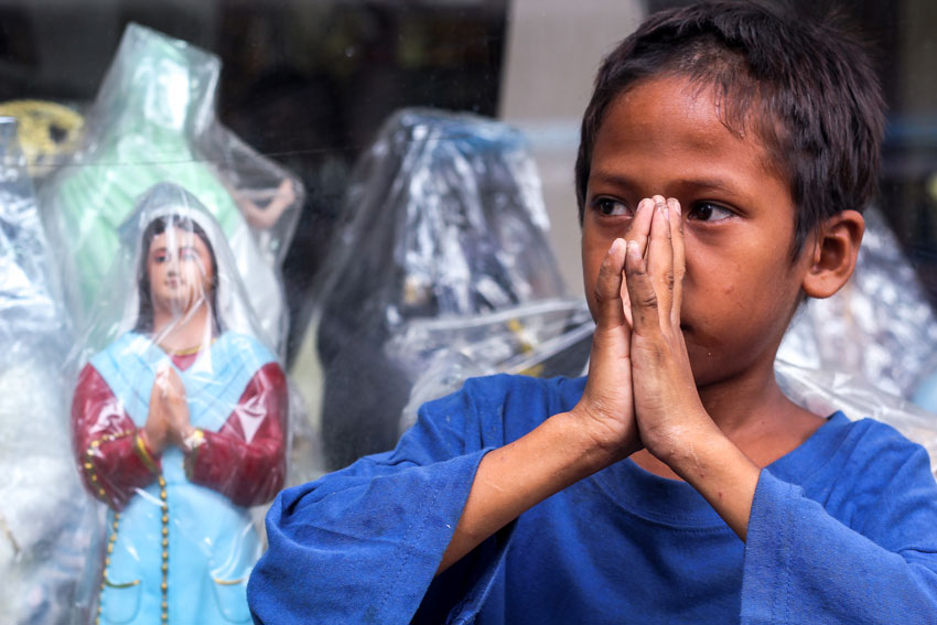 POTRAYING IMAGE. A street child mimics a religious statue displayed along downtown Bolton street of Davao City. (Ace R. Morandante/davaotoday.com)