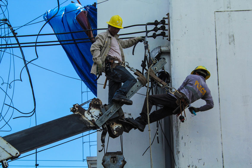 Workers of a telecommunication company fix some cable wire along Bonifacio street, this City. (Ace R. Morandante/davaotoday.com)