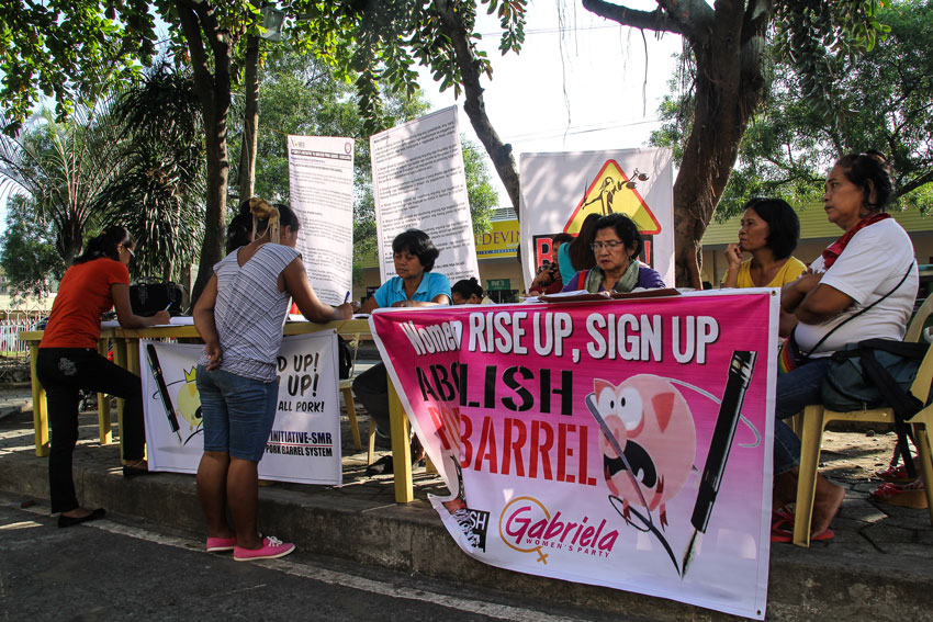 A group of women under Gabriela Women's  Party-list gather along Freedom Park in Roxas Avenue Monday to collect signatures for a bill supporting the abolition of pork barrel and the Disbursement Acceleration Program (DAP) via People’s Initiative. (Ace R. Morandante/davaotoday.com)