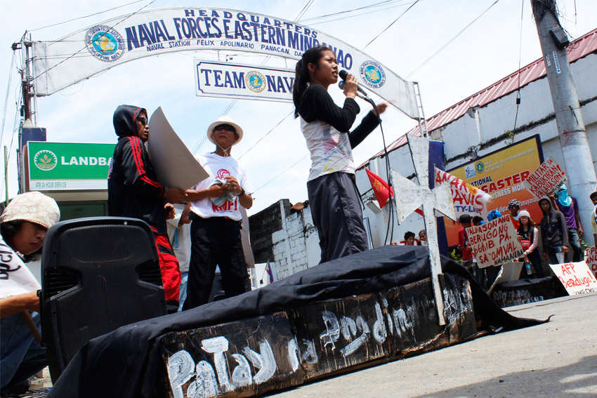 Members of progressive organizations stage a protest action Friday in front of the headquarters of the Eastern Mindanao Command of the AFP in Panacan. Two caskets made out of card boxes were displayed by the protesters as symbols of the death of Lando Dagansan, and his son, Judah who were brutally killed by members of the 66th Infantry Battalion last October 12.  (Medel V. Hernani/davaotoday.com)