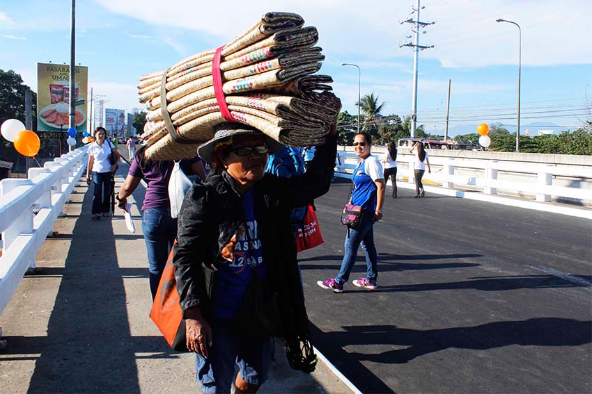 A mat peddler was among the first to walk through the reopened Bankerohan bridge. It's a long day ahead for this old woman who leaves home after a cup of coffee as early as 5 in the morning and arrives at the city's biggest public market at 7 o'clock. (Medel V.Hernani/davaotoday.com)