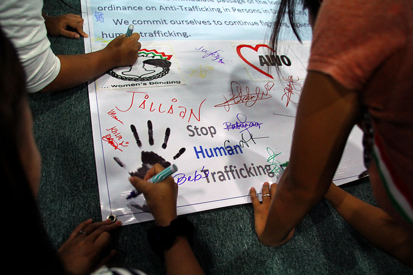 Victims of human trafficking and their supporters from various barangays in the city signify support to stop human trafficking by signing a unity statement Friday. (Ace R. Morandante/davaotoday.com)